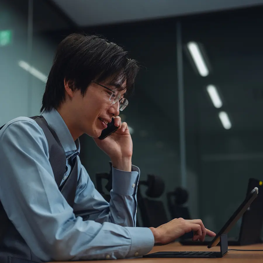 電話をしながらパソコンを操作する社員
